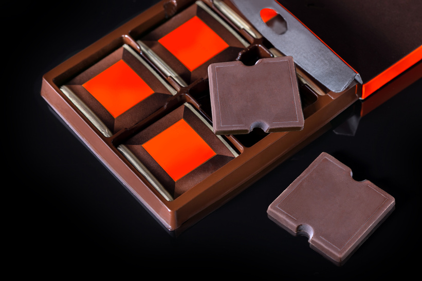 Premium chocolate ads. Chocolate bars in box on black background.